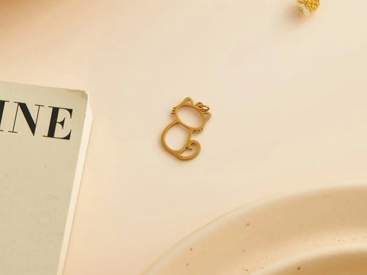 Dije de acero dorado con diseño de gato calado